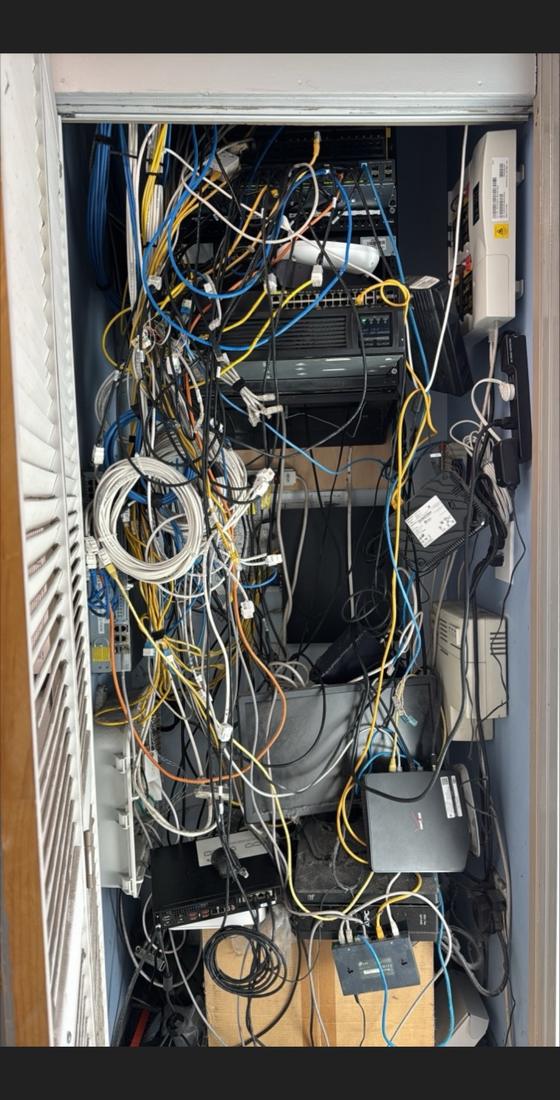 Before: Medical office IT closet: rebuilt with an organized rack and battery backup